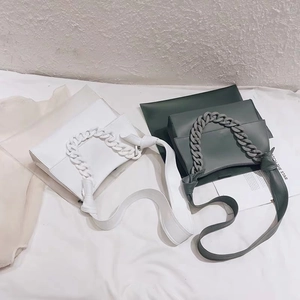 Detail of white and dark green acrylic chain handbags with matte resin shoulder straps