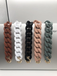Detail of five chunky acrylic bag straps in assorted colors with gold metal rings