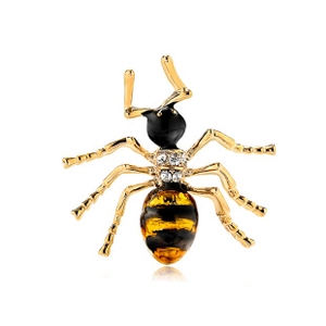 Macro shot of gold insect brooch with amber stripes and sparkling rhinestones