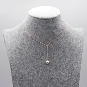 Adjustable gold chain necklace with white pearl pendant on velvet bust display