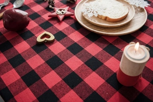 Detail of red and black buffalo plaid cotton linen tablecloth with festive holiday decor