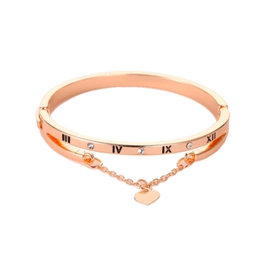 Rose gold Roman numeral bracelet with heart pendant and white crystals on white background