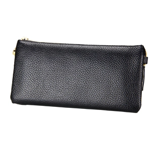 Detail shot of black pebbled leather texture and golden metal zipper on shoulder bag