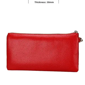Detail view of red leather crossbody bag showing 30mm thickness and litchi texture