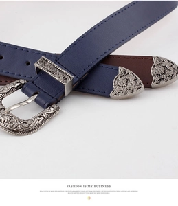 Vue détaillée de la boucle vintage sculptée et de la texture du cuir sur la ceinture bleue