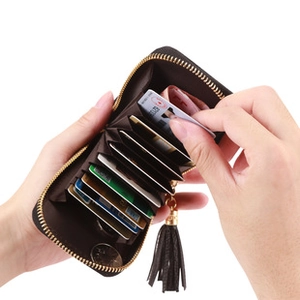 Dettaglio porta carte marrone scuro con scomparti multipli e nappina in pelle e zip