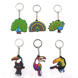 Detail of colorful PVC animal keychains featuring peacock and toucan jungle designs