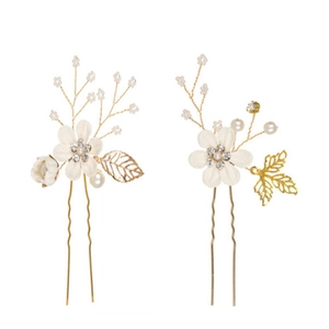 Detailed shot of gold bridal hair pins with white fabric flowers and faux pearls
