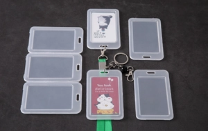 Flat lay of translucent frosted plastic ID card holders with green lanyards and keyrings