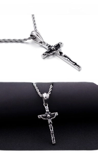 Close-up of vintage stainless steel cross pendant with detailed skull skeleton carving