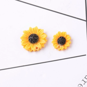 Detailed view of yellow resin sunflower charms with hanging holes for DIY jewelry