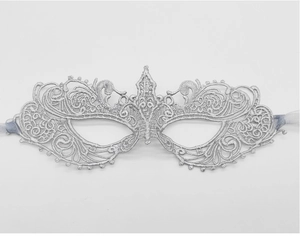 Detail view of silver lace masquerade mask with intricate embroidery and silk ribbons