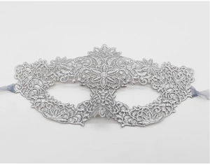 Detail of silver lace masquerade mask showing intricate embroidery and silk ribbons