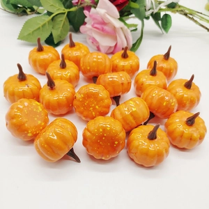 Top view of mini orange artificial pumpkins with speckled texture and glossy finish