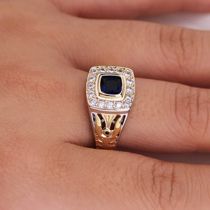 Close-up of a two-tone men's ring featuring a blue square stone and diamond halo