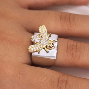 Eleganter silberner Ring mit goldener Biene und Zirkon-Steinen am Finger getragen