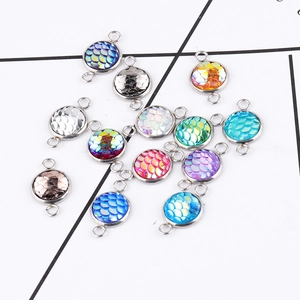 Macro shot of 10mm round fish scale charms with double loops in various colors for DIY