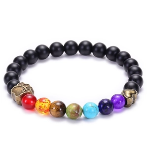 Detail eines Lavasteinarmbands mit Regenbogenperlen und antikem Pfoten- und Herzanhänger