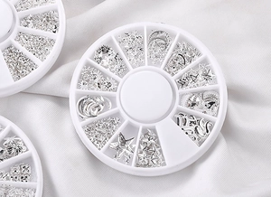 Detail of 12-slot cases filled with silver metal star and moon nail art charms