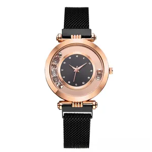 Detail of rose gold watch with moving crystals and black magnetic mesh strap