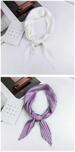 Detailed view of pleated silk scarves in white and purple with fine vertical accordion folds