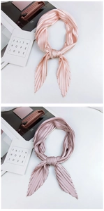Detailed view of pleated satin square scarves in soft peach pink and elegant mauve tones