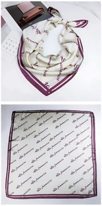 Detail of elegant silk square scarf featuring letter prints and purple borders