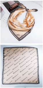 Detail of champagne gold silk square scarf with elegant black letter patterns