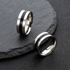 Detail of silver stainless steel rings with black enamel inlay on natural slate