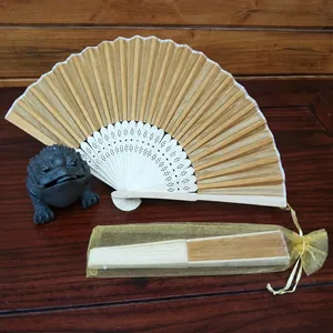 Detailed view of personalized wood folding fans in elegant gold organza gift pouches