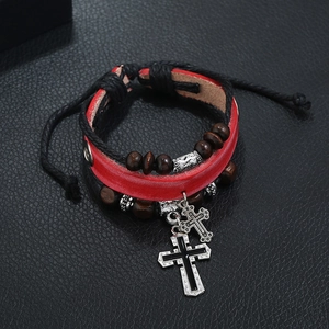 Detail of multilayer leather bracelet with wooden beads and two metal cross pendants