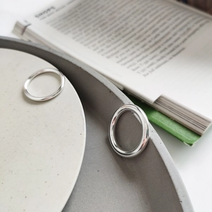 Close-up of S925 sterling silver minimalist thin rings on a textured background