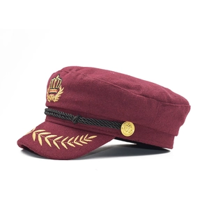 Vue détaillée d'une casquette de marin bordeaux avec une broderie de couronne dorée