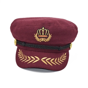Broderie dorée de couronne et d'épis de blé sur le bord d'une casquette marin bordeaux