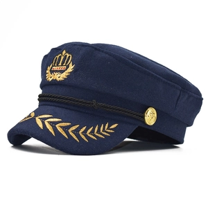 Détail de casquette de capitaine avec broderies dorées et cordon noir tressé