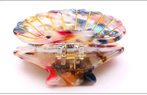 Detail view of acetate shell hair claw with marble texture and gold wire inlay