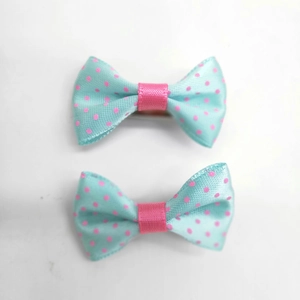 Detail view of light blue hair clips with pink polka dots for pets or babies