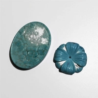 Detailed view of turquoise natural stone spacer beads with intricate floral carvings