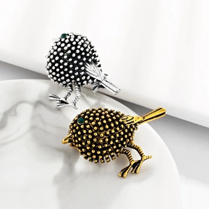 Retro sparrow bird brooches in gold and silver finish with green gemstone eyes on marble