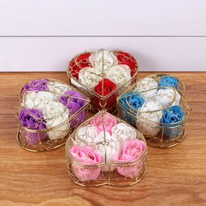 Detailed view of heart-shaped wire baskets with soap roses in various colors on wood surface
