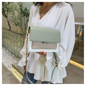 Close-up of tricolor contrast flap bag with metal chain strap and minimalist buckle