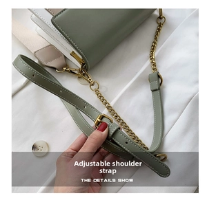 Sage green leather strap with adjustable bronze metal chain and fine texture detail