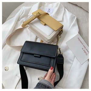 Close-up of minimalist contrast color crossbody bags with metal chains and wide straps