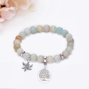 Detail showing natural stone beaded bracelet with tree of life and flower pendants
