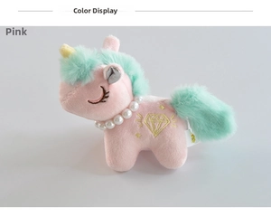 Detail shot of a pink plush unicorn with pearl necklace and gold diamond embroidery