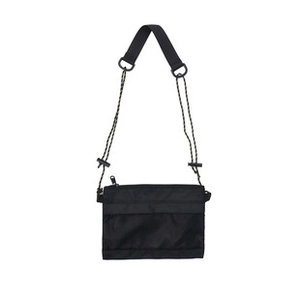 Detailed flat lay of a black minimalist nylon crossbody bag against a plain white backdrop