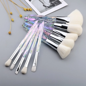Detailed flat lay of 10 crystal handle makeup brushes with white bristles and silver ferrules
