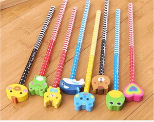 Detail of HB pencils with assorted cartoon animal erasers on a wooden table surface