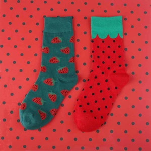 Detail view of cotton crew socks with strawberry patterns in green and red polka dot colors