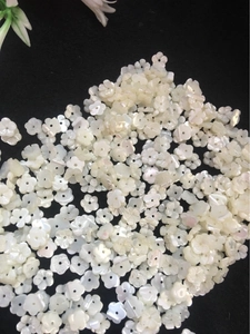 Detailed macro view of 10mm white shell flower beads for DIY jewelry making